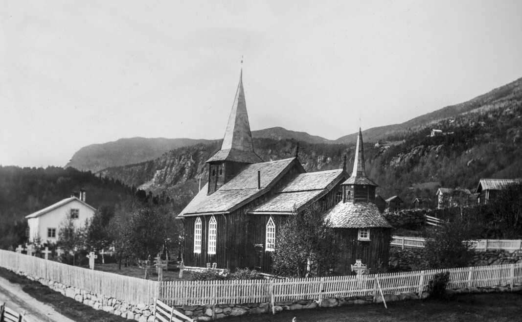 Hol gamle kyrkje og kyrkjegard med tradisjonelle gravkors i tre og/eller støpejern. Foto fra begynnelsen av 1900-tallet.